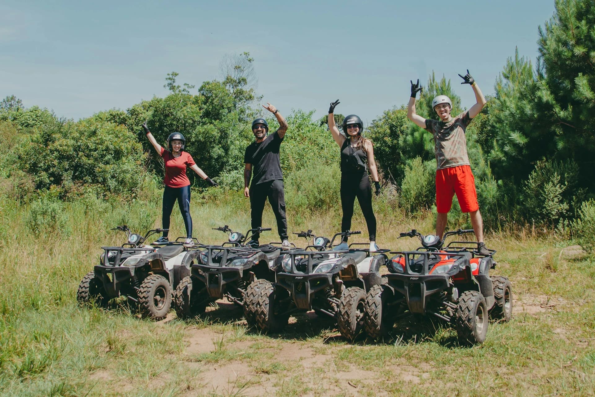 Rider on a quad bike crossing a muddy mountain trail in the green hills outside Medellín