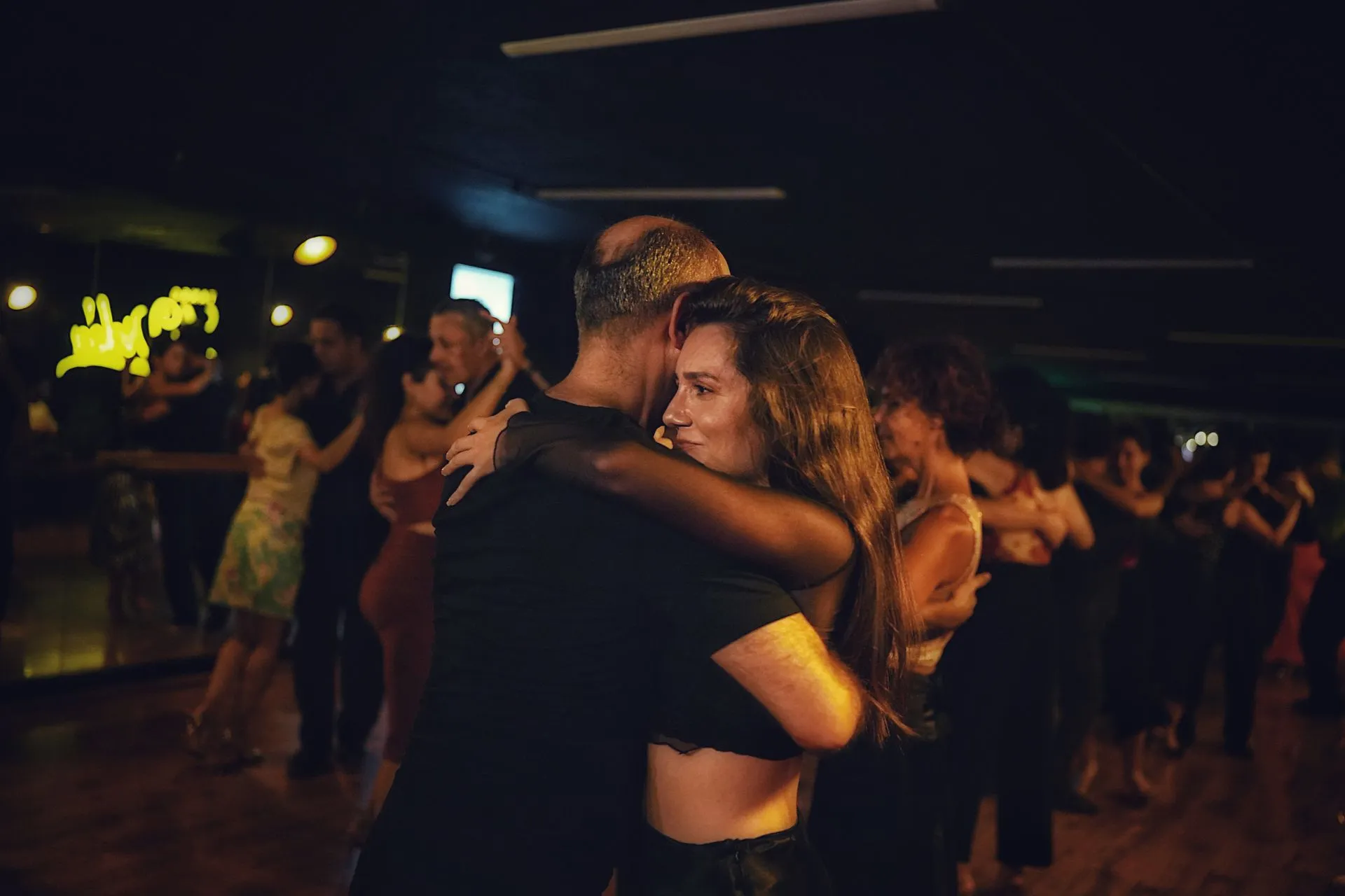 Couple dancing salsa on a crowded floor at a Laureles salsa bar in Medellín