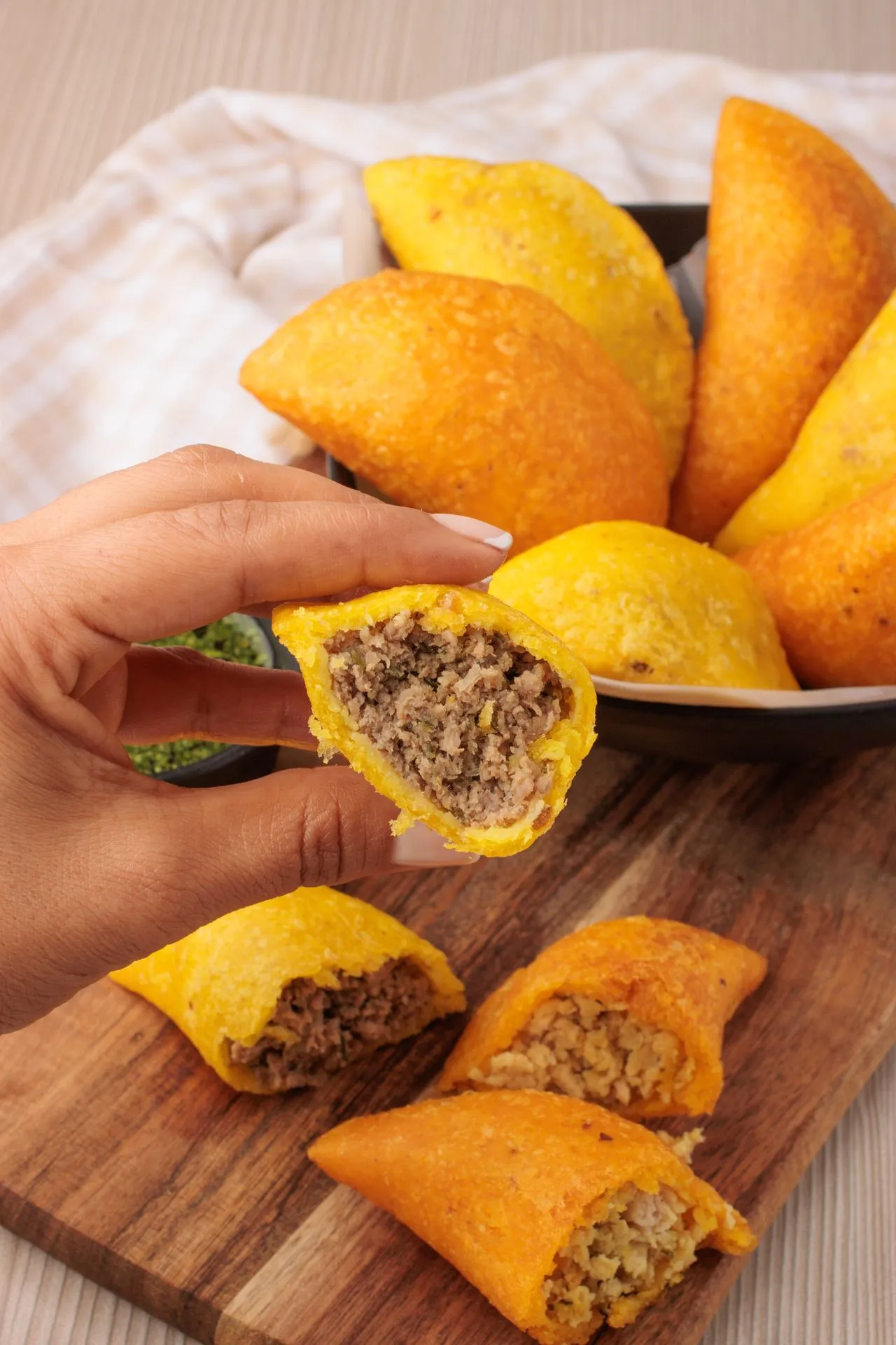 Golden fried Colombian empanadas stacked on a market counter in Medellín